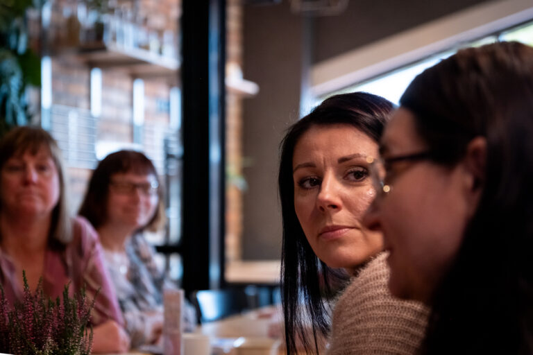 Cztery kobiety siedzące razem przy stole w restauracji.